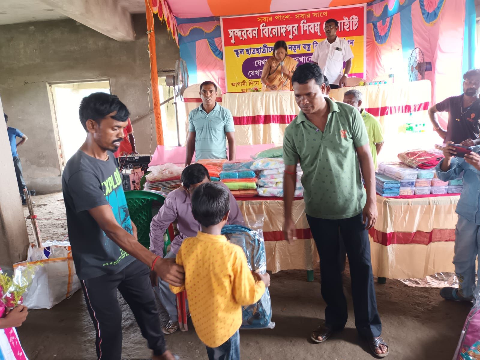 A volunteer handing new clothes to a young boy