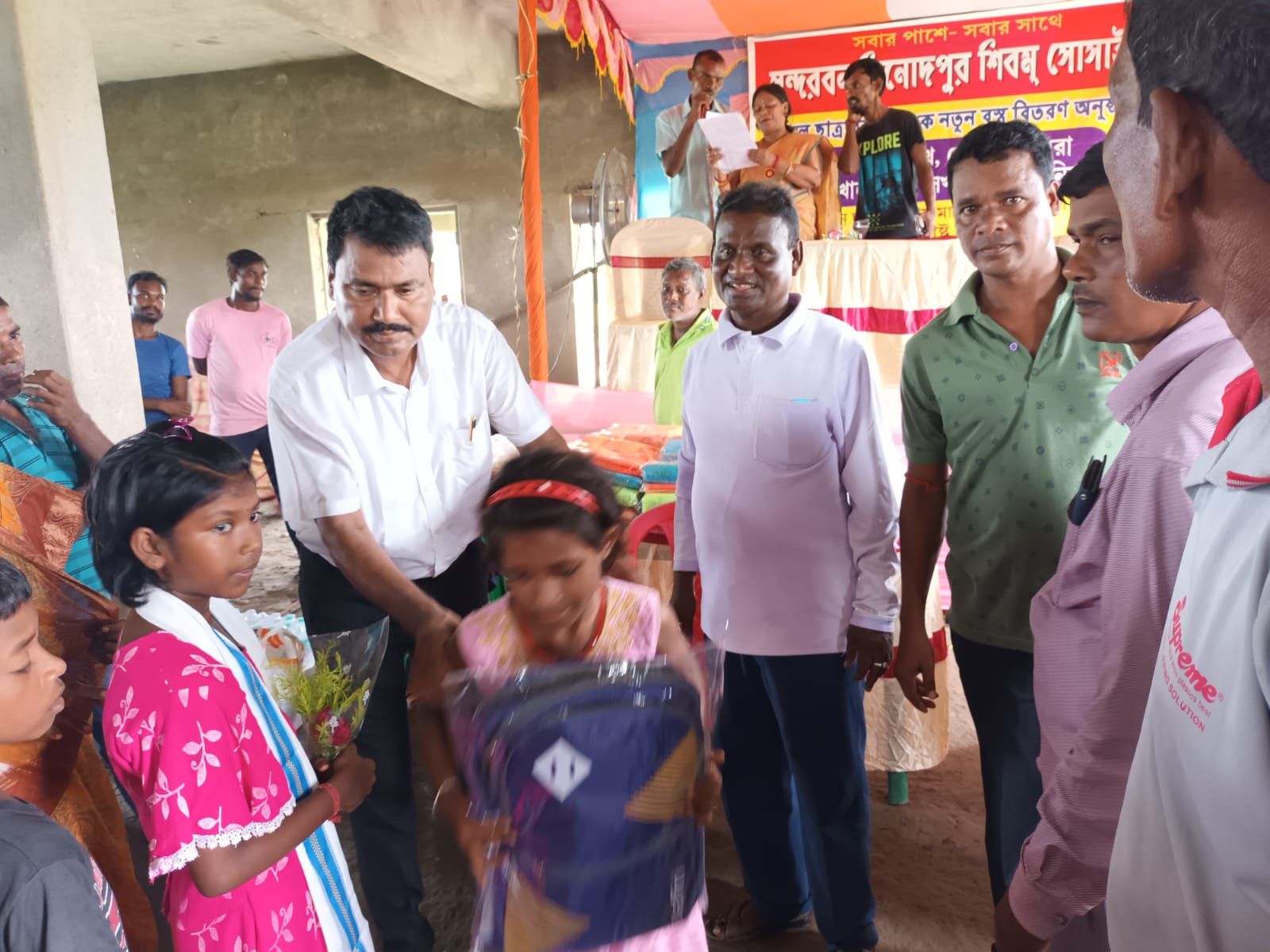 Children receiving gifts from volunteers at a community programme