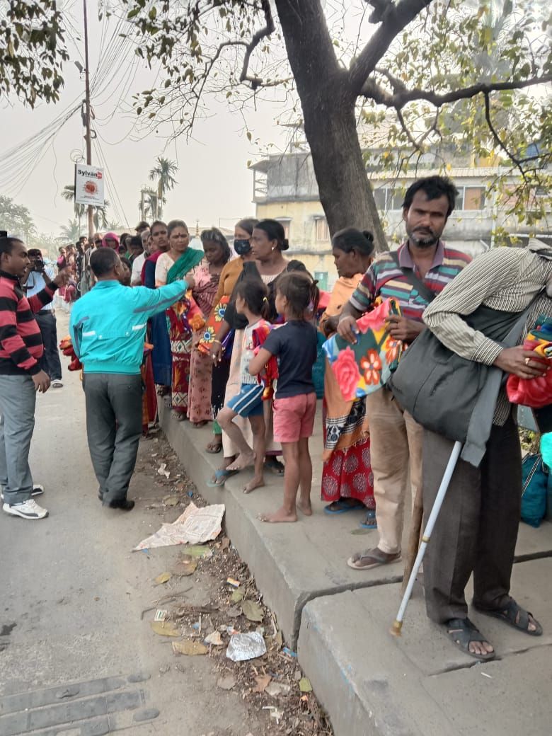 Families waiting along a roadside for relief supplies