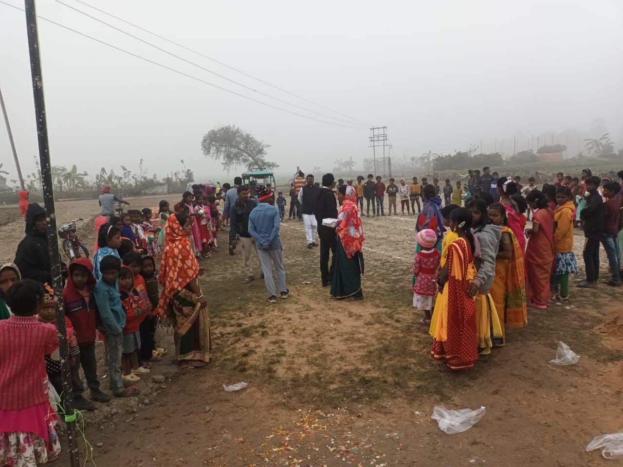 Villagers gathering on a foggy winter morning for a relief programme